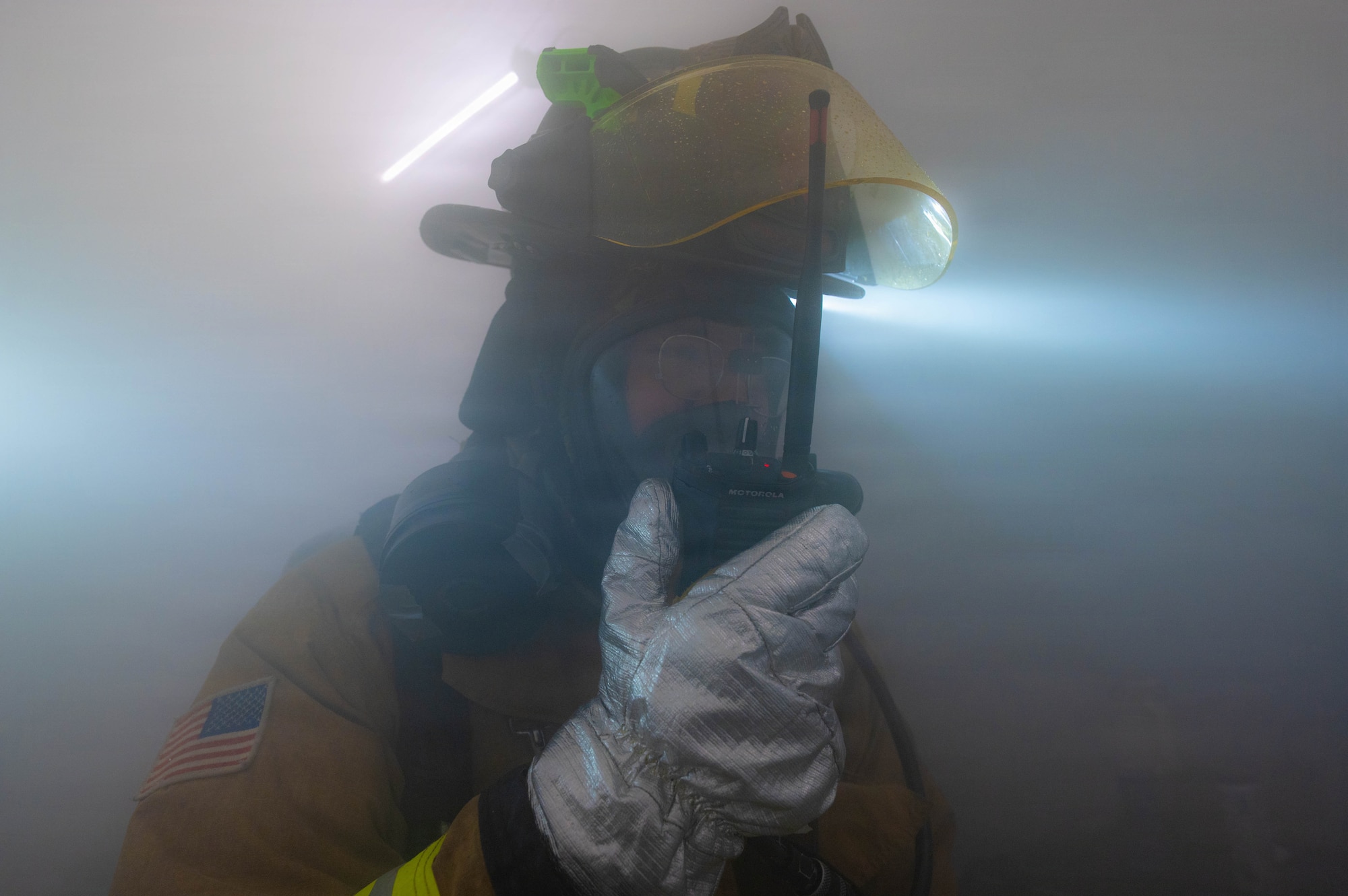 Firefighter uses radio.