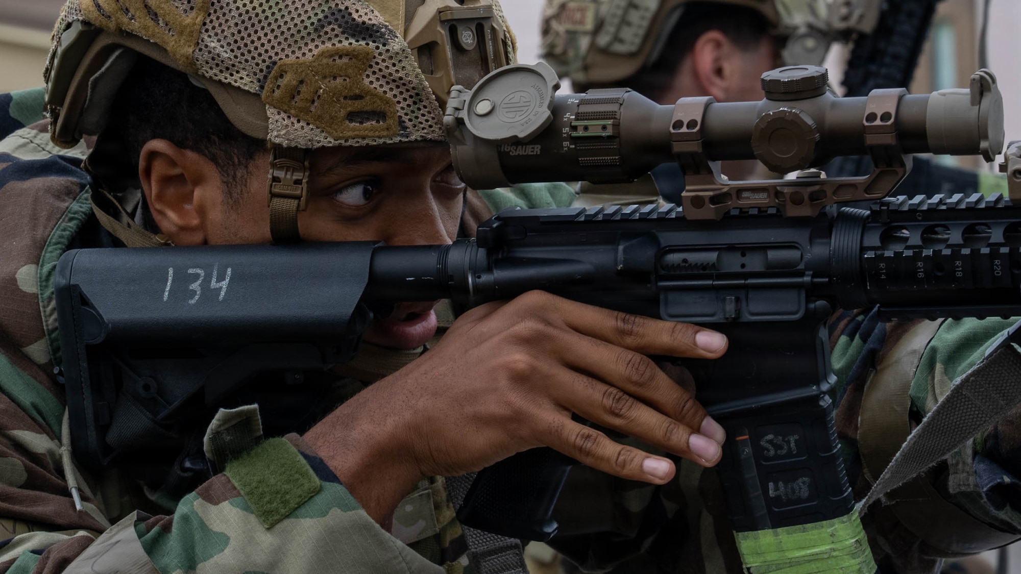 Airman aims weapon during simulated opposing forces scenario.