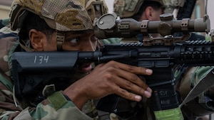 Airman aims weapon during simulated opposing forces scenario.