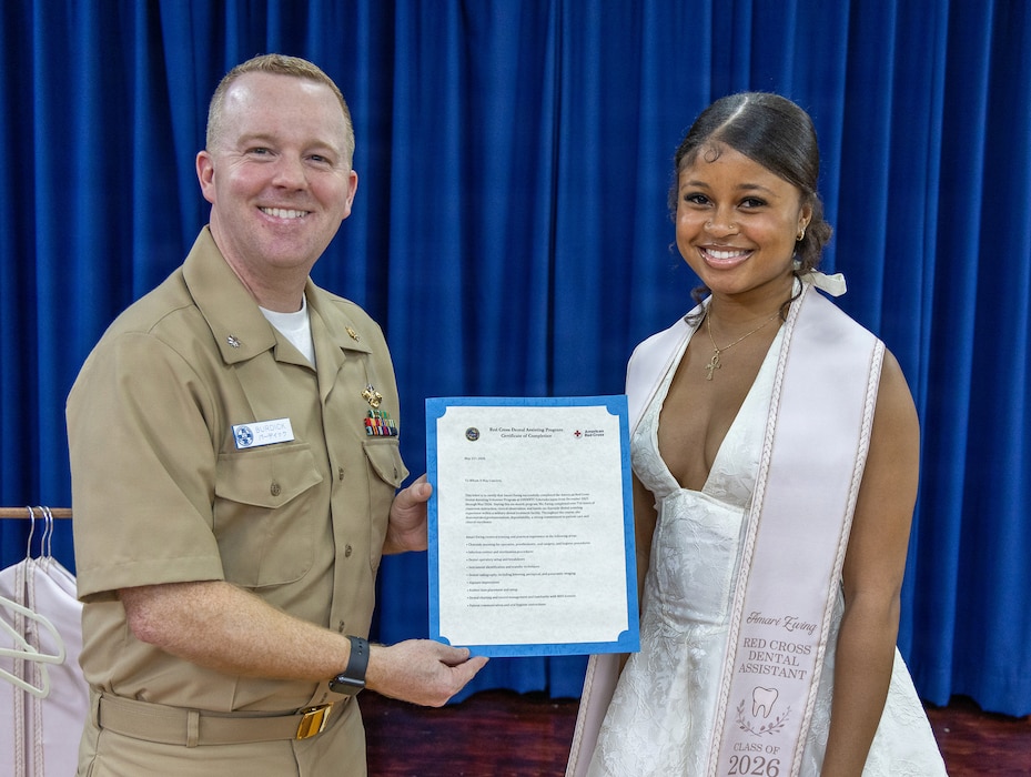 YOKOSUKA, Japan (May 21, 2026) — Cmdr. Mathew Burdick, director for Dental Services at U.S. Naval Hospital Yokosuka, presents a letter of completion to Amari Ewing during a Red Cross Dental Assistant Program recognition ceremony at U.S. Naval Hospital Yokosuka. The revitalized Red Cross Dental Assistant Program provides participants with more than 600 hours of classroom instruction, clinical observation and hands-on training while supporting patient care and workforce development within Navy Medicine. (U.S. Navy photo by Daniel Taylor/USNMRTC Yokosuka Public Affairs)