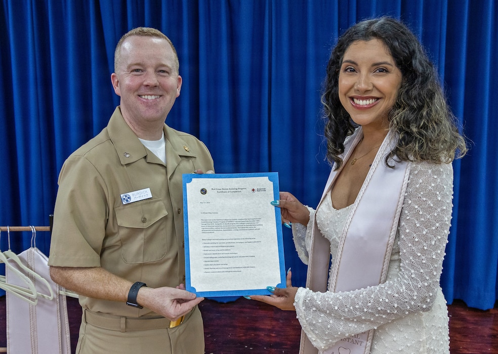 YOKOSUKA, Japan (May 21, 2026) — Cmdr. Mathew Burdick, director for Dental Services at U.S. Naval Hospital Yokosuka, presents a certificate of completion to Mona Gallegos during a Red Cross Dental Assistant Program recognition ceremony at U.S. Naval Hospital Yokosuka. The revitalized Red Cross Dental Assistant Program provides participants with more than 600 hours of classroom instruction, clinical observation and hands-on training while supporting patient care and workforce development within Navy Medicine. (U.S. Navy photo by Daniel Taylor/USNMRTC Yokosuka Public Affairs)