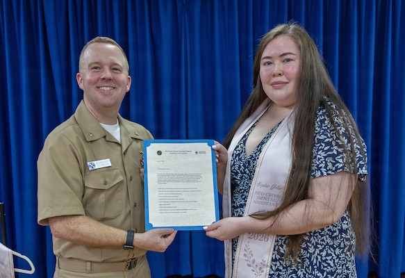 YOKOSUKA, Japan (May 21, 2026) — Cmdr. Mathew Burdick, director for Dental Services at U.S. Naval Hospital Yokosuka, presents a certificate of completion to Sophie Geller during a Red Cross Dental Assistant Program recognition ceremony at U.S. Naval Hospital Yokosuka. The revitalized Red Cross Dental Assistant Program provides participants with more than 600 hours of classroom instruction, clinical observation and hands-on training while supporting patient care and workforce development within Navy Medicine. (U.S. Navy photo by Daniel Taylor/USNMRTC Yokosuka Public Affairs)