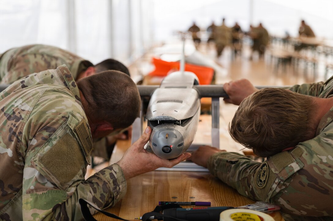 U.S. Army Staff Sgt. Nicholas Davis, Staff Sgt. Terrence Giles and Spc. Octavio Landeros, all with the Field Artillery Squadron, 2d Cavalry Regiment, check the center of gravity of a one-way attack Hornet drone after assembly in preparation for flight operations at Bemowo Piskie Training Area, Poland, May 3, 2026. From April 27 to May 31, 2026, U.S. and Allied forces will exercise NATO’s Eastern Flank Deterrence Initiative, demonstrating NATO’s ability to fight and win on the modern battlefield. Nearly 15,000 troops from eleven nations will train across the High North, Baltic region, and Poland, executing rapid maneuvers, air defense, counter-drone operations, and cyber defense to validate NATO’s regional defense plans in real time. This series of linked exercises, including Saber Strike, Immediate Response, and Swift Response, turns investment into capability. Soldiers integrate unmanned systems, AI-enabled command and control, and live data networks to move faster, decide faster, and fight more effectively across all domains. Sword 26 demonstrates how U.S. Army Europe and Africa drives transformation at scale while strengthening deterrence. Together with our Allies, we are building a unified, lethal force ready to defend NATO territory and respond to any threat. (U.S. Army Reserve photo by Capt. Katherine Bustos)
