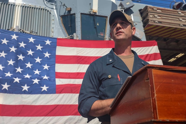Cmdr. R. J. DaPrato, commanding officer of USS Roosevelt (DDG 80), make his first address to the crew, on the flight deck of Roosevelt, May 22, 2026. Daprato relieved Cmdr. Jared L. Carlson from command of Roosevelt during the ceremony.