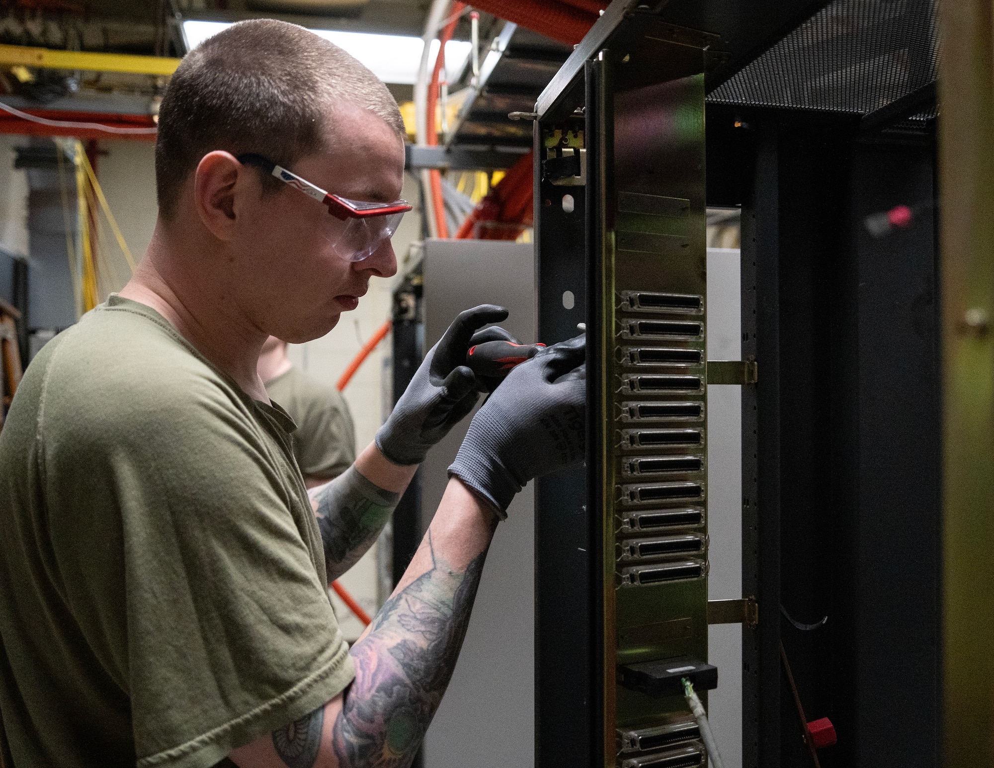 U.S. Air Force Staff Sgt. Robert Hyde, 133rd Communications Squadron, unscrews parts of an old server rack at Osan Air Base, South Korea, March 13, 2026.