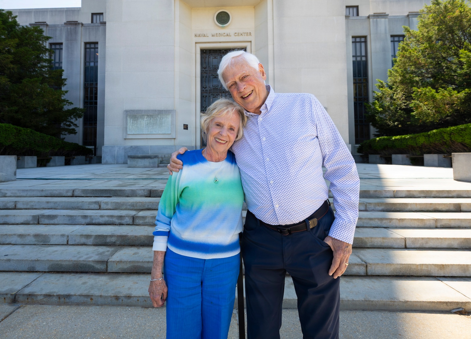 Former U.S. Navy pilot Mike Flannery and his wife, Carol, a former U.S. Navy nurse, pose in front of Walter Reed National Military Medical Center, May 18, 2026, in Bethesda, Maryland. The couple met at the hospital in 1969 when Mike was recovering from injuries sustained aboard the USS Enterprise (CVN-65). (DOW photo by Ricardo J. Reyes)