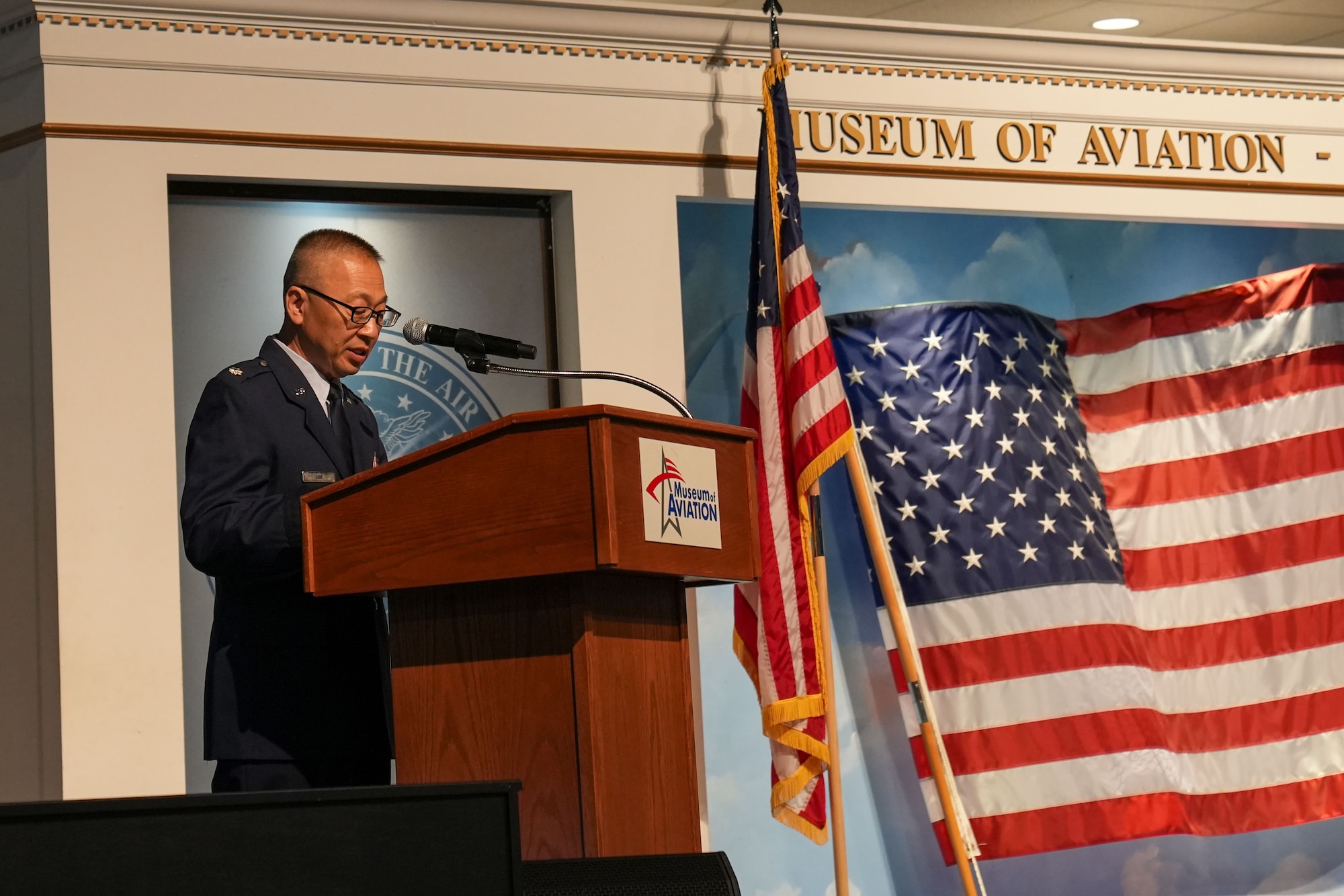 Man in military uniform speaks at podium on stage