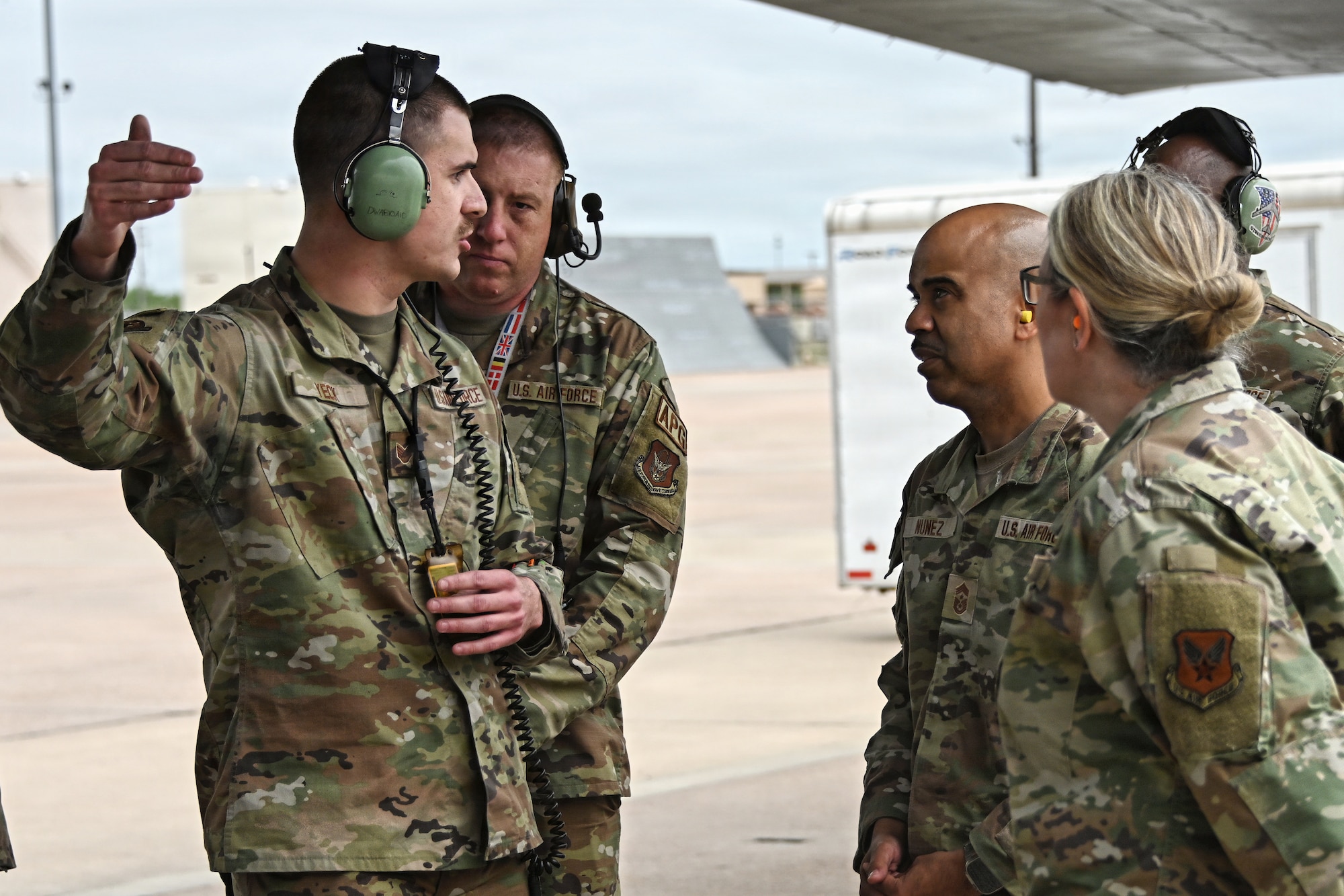 Airmen speak together outside on the flightline under a B-1B Lancer