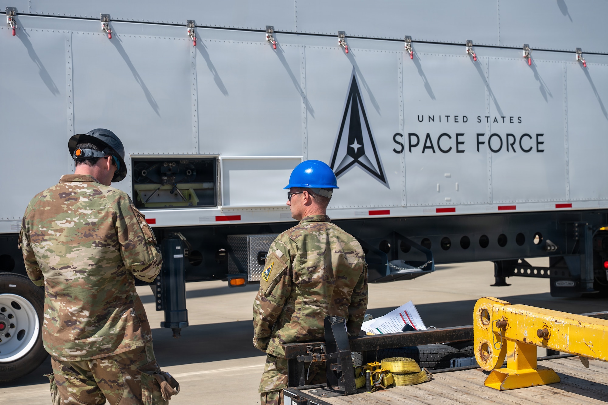 Space Force leadership stand in front of trailer.