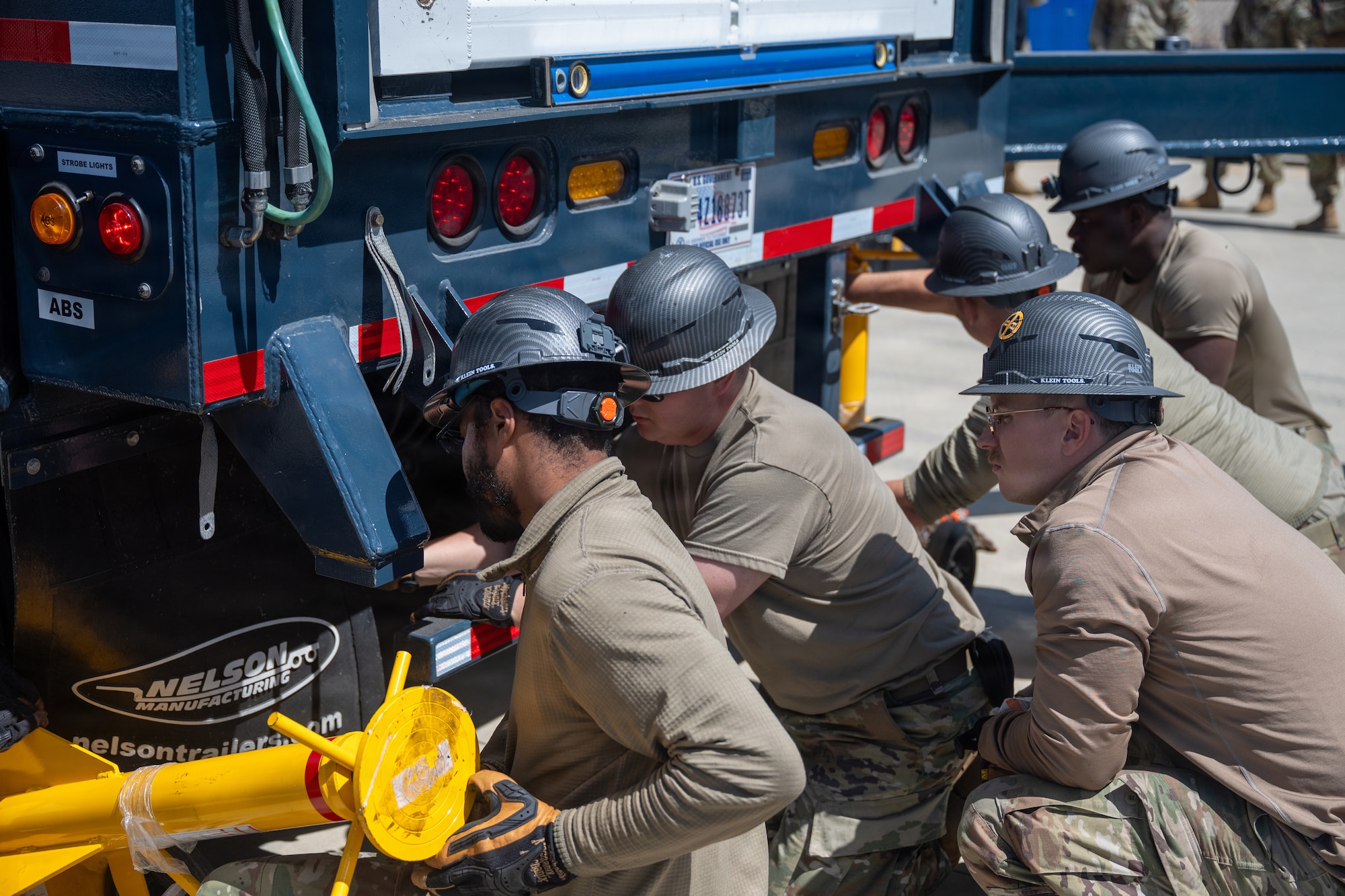 Air Force troops attach support bars to the end of the trailer.