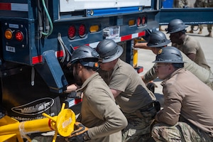 Air Force troops attach support bars to the end of the trailer.