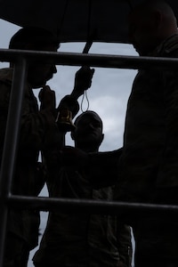 U.S. Air Force Airmen with the 621st Contingency Response Wing are silhouetted beneath an umbrella during the Air Advisor Memorial Foundation’s 14th Annual Remembrance Ceremony at Joint Base McGuire-Dix-Lakehurst, N.J., May 21, 2026.