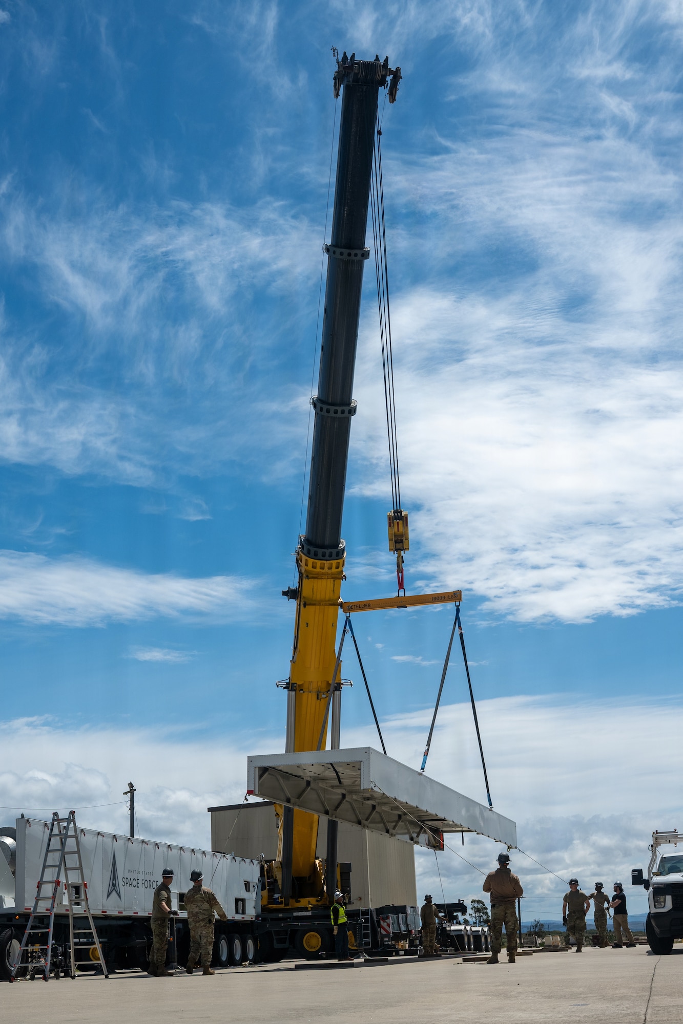 A crane pulls the roof off the trailer and places it to the side.