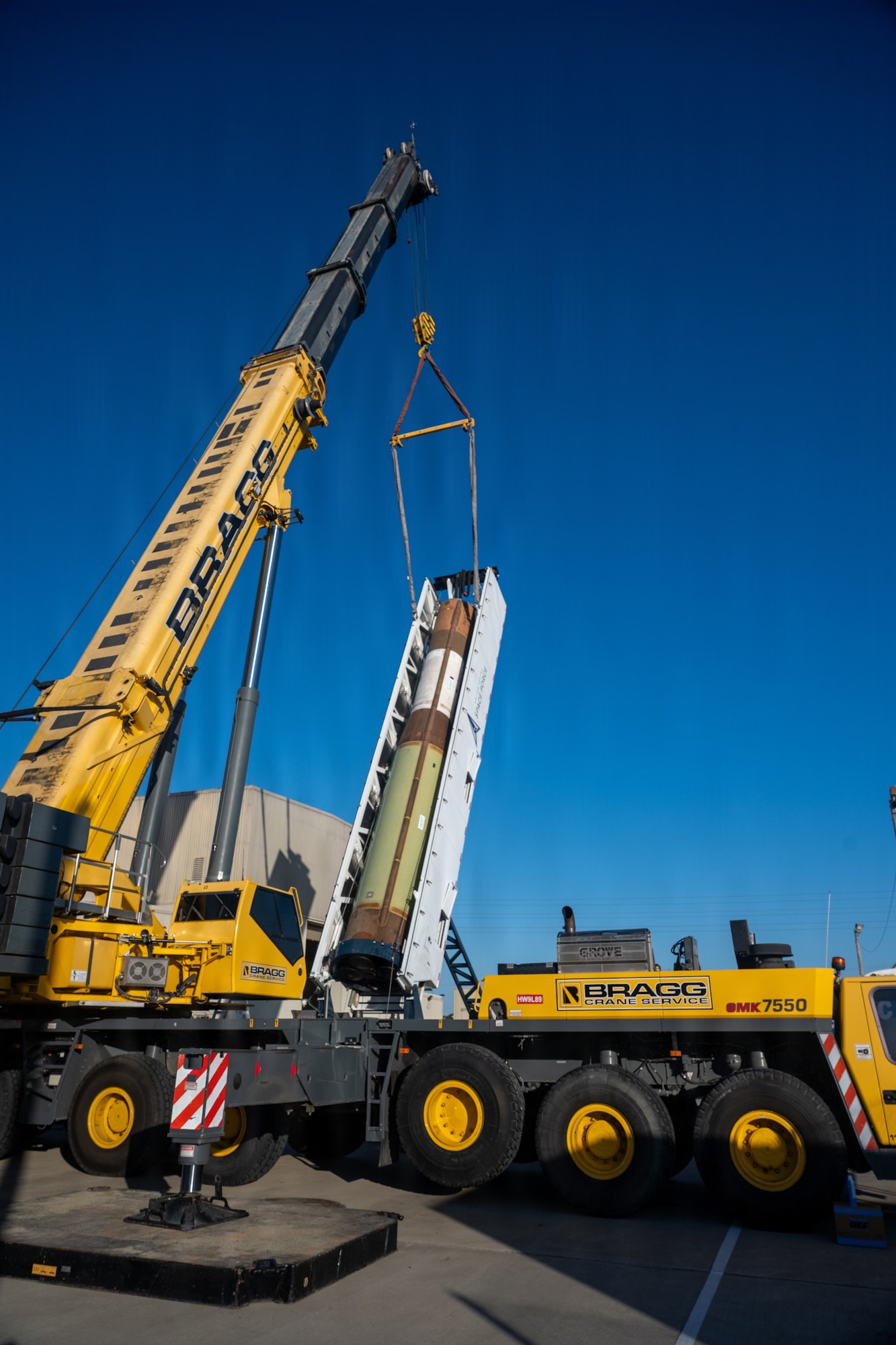 Crane lifts the strongback container.