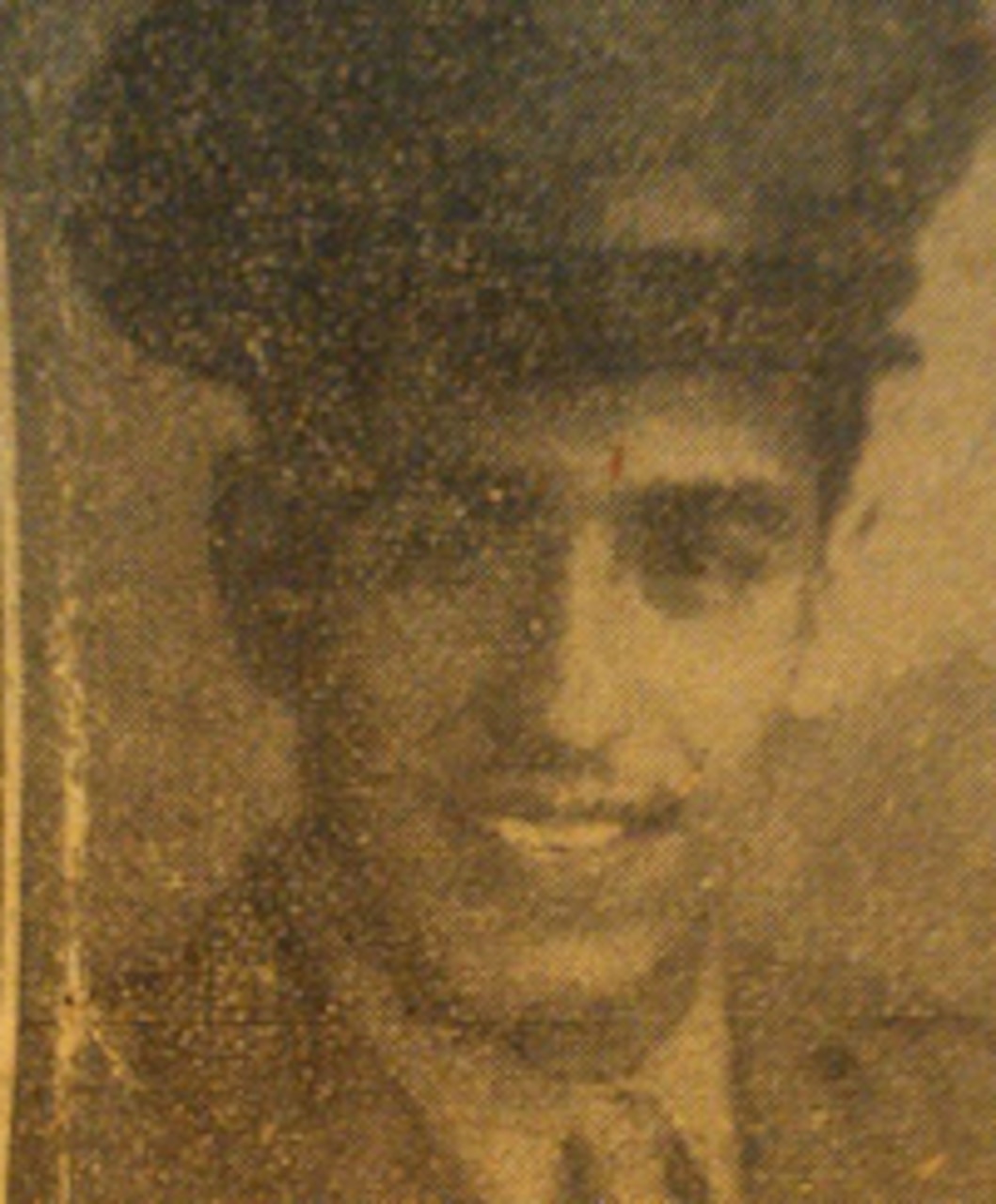 A man in a formal military uniform smiles for a portrait.