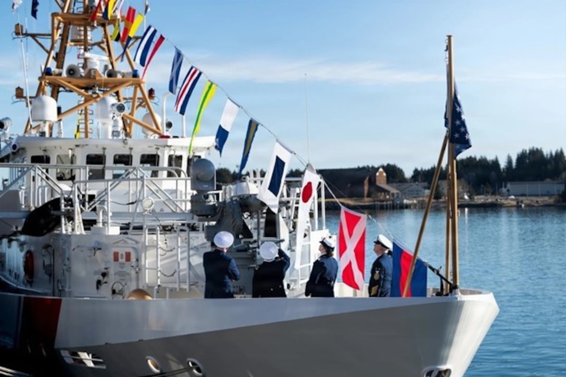 Coast Guard service members view the signal flags on display on a ship.