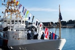 Coast Guard service members view the signal flags on display on a ship.
