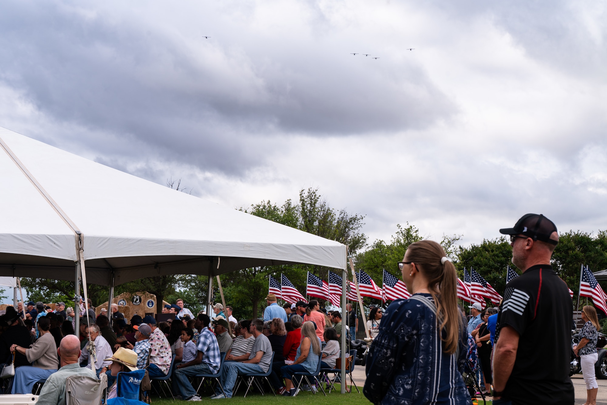 Event attendees observe a missing man formation flyover during a Memorial Day ceremony at the Texas State Veterans Cemetery at Abilene, Texas, May 25, 2026. The outdoor observance drew hundreds of local residents, veterans and military families to the cemetery to honor those who made the ultimate sacrifice. (U.S. Air Force photo by Senior Airman Jade M. Caldwell)