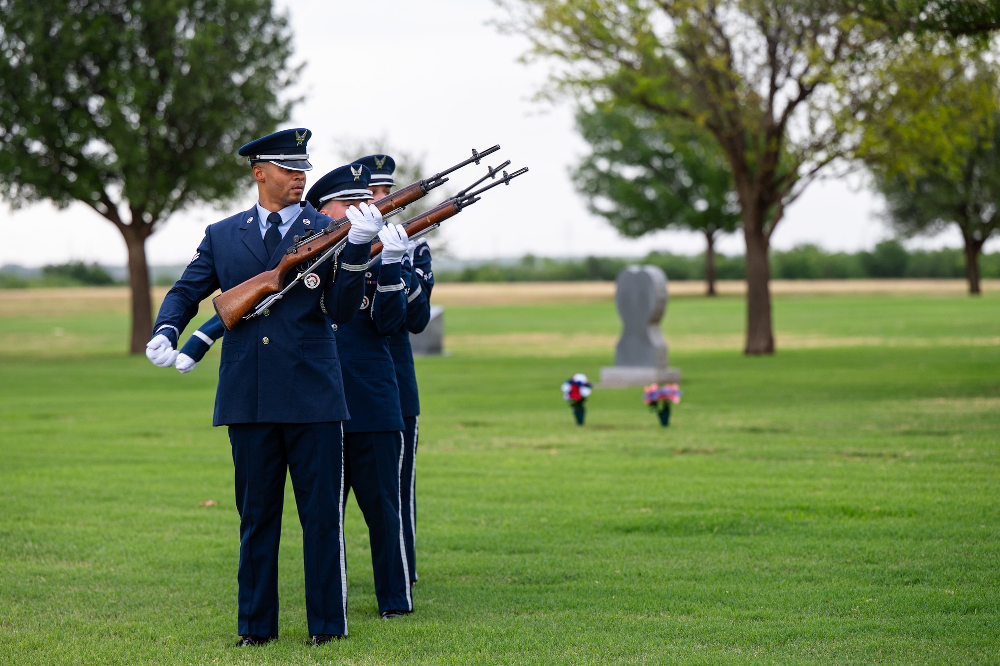 Members of the Dyess Air Force Base Honor Guard fire volleys during a Memorial Day ceremony at the Texas State Veterans Cemetery at Abilene, Texas, May 25, 2026. Historically, three volleys of rifle fire were fired in a combat environment to indicate that casualties had been cared for and fighting could resume; as time passed, these volleys became an official military custom during funeral and memorial services. (U.S. Air Force photo by Senior Airman Jade M. Caldwell)