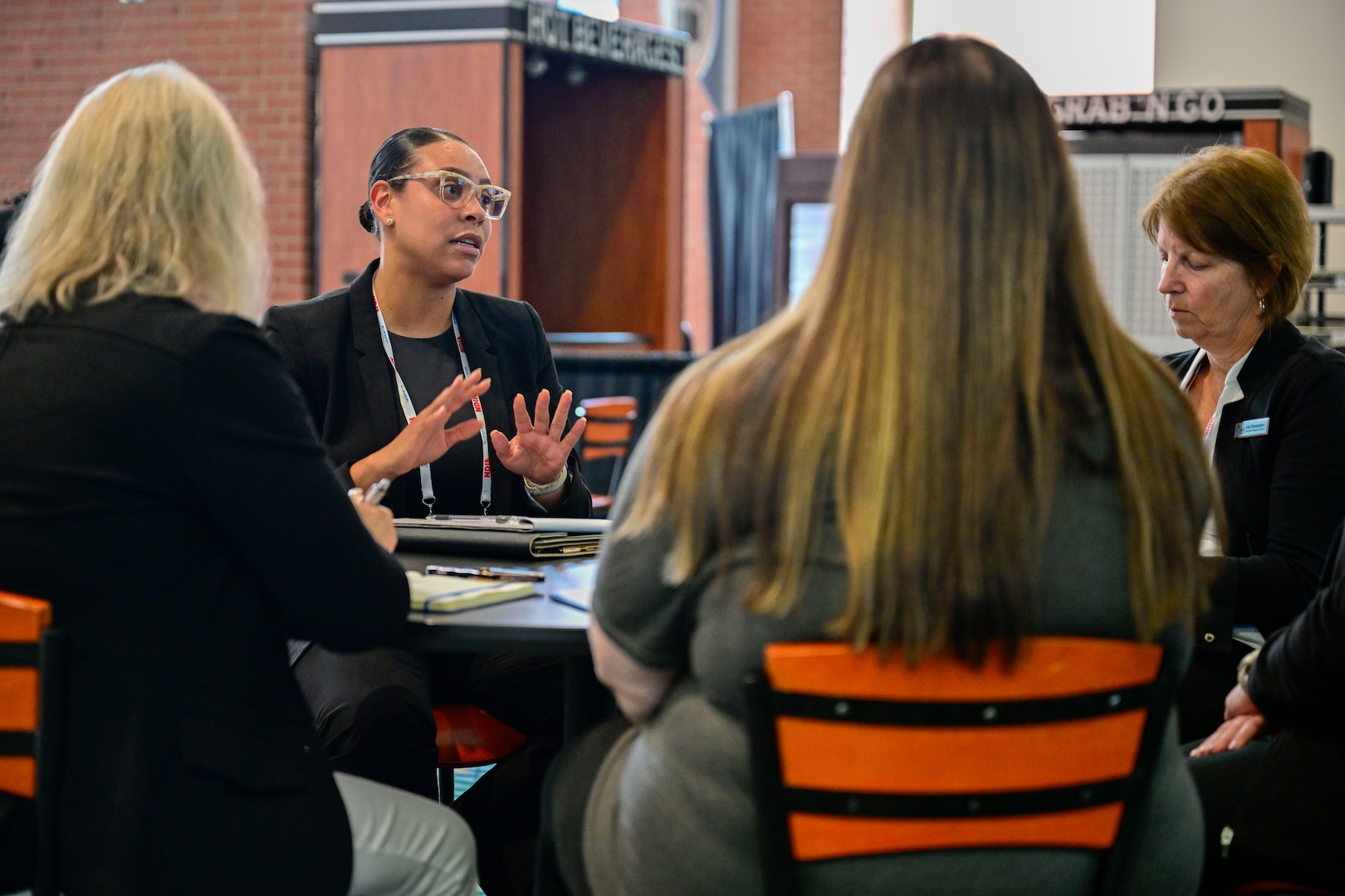 A group of people converse around a table in a cafeteria.