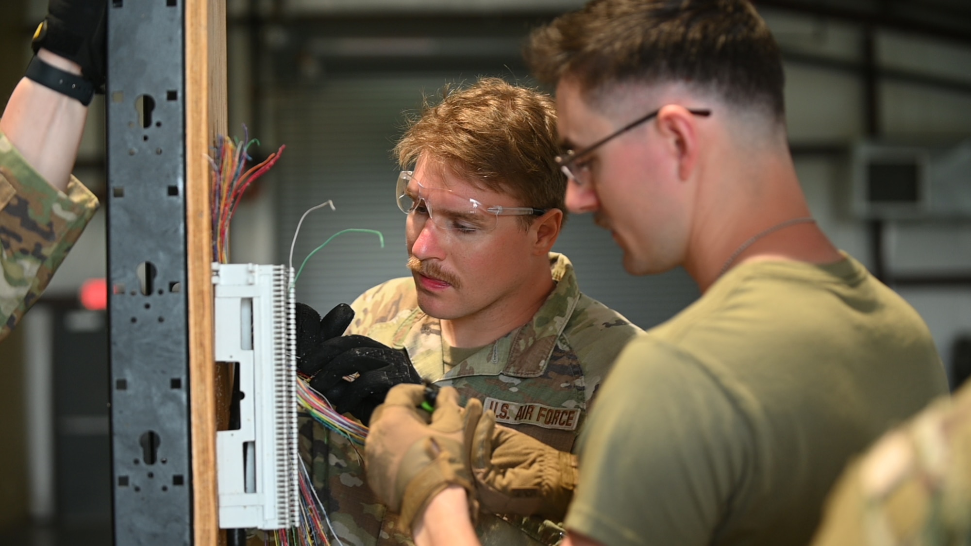 U.S. Air Force Staff Sgt. Dawson Buss and Senior Airmen John Kabliska, 210th Engineering Installation Squadron, install and connect a 66-block for critical voice communications at Camp Gruber Training Center, Oklahoma, April 29, 2026.