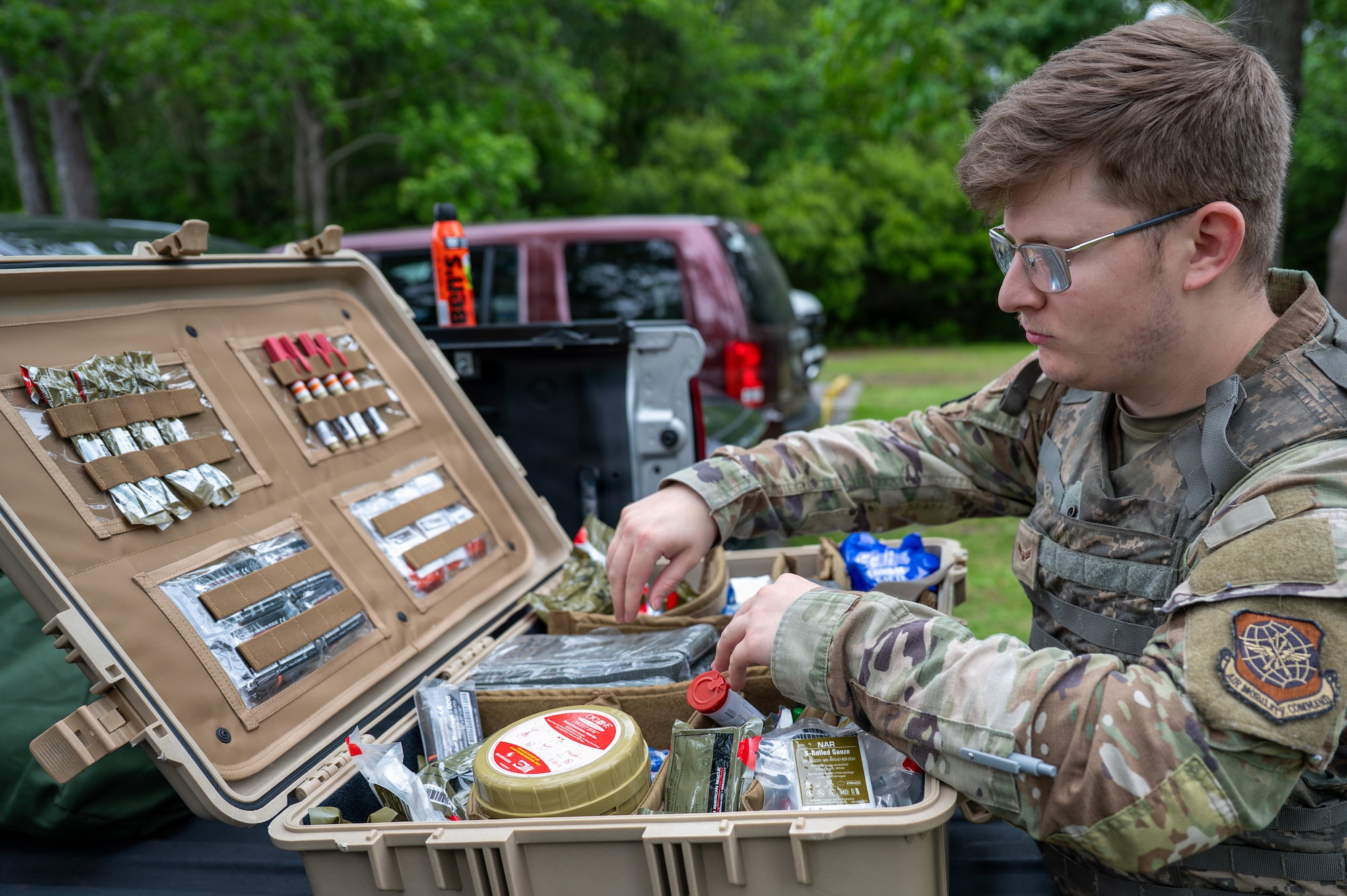 An Airman rummages in a case full of various medical supplies.