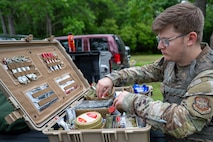 An Airman rummages in a case full of various medical supplies.