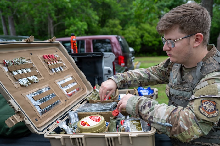 An Airman rummages in a case full of various medical supplies.