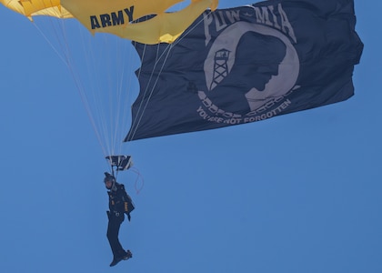 A member of the U.S. Army Golden Knights parachute team descends with a Prisoner of War/Missing in Action flag during the Hyundai Air and Sea Show in Miami Beach, Florida, May 24, 2026. The annual Memorial Day weekend event honored members of the U.S. Armed Forces through aerial demonstrations, parachute performances and military equipment displays. (U.S. Army photo by Spc. Jose Rolando Garcia)