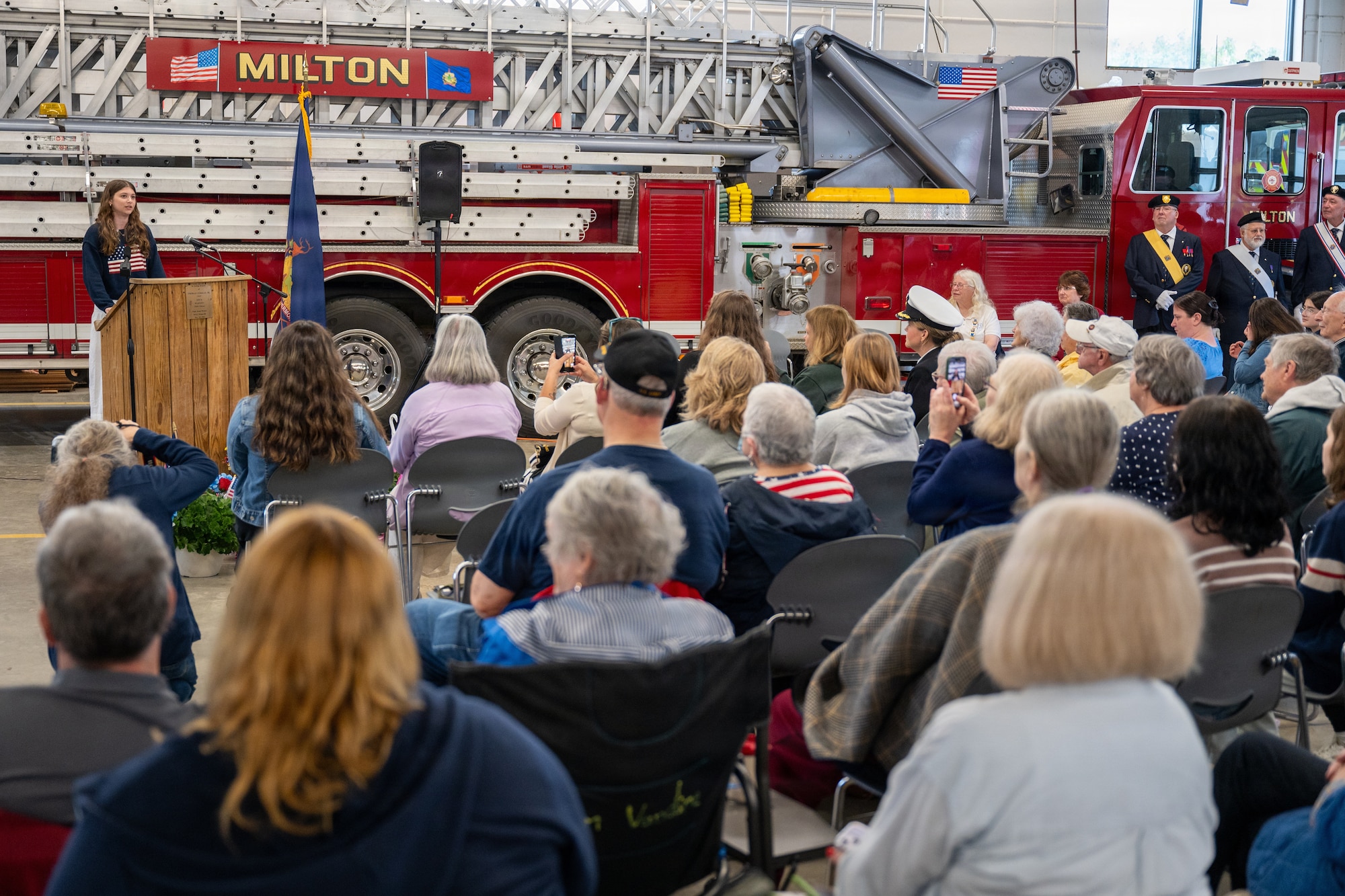 Photo of Brooke Adams, daughter of a currently deployed service member, delivering remarks during a Memorial Day ceremony in Milton, Vt., May 25, 2026.