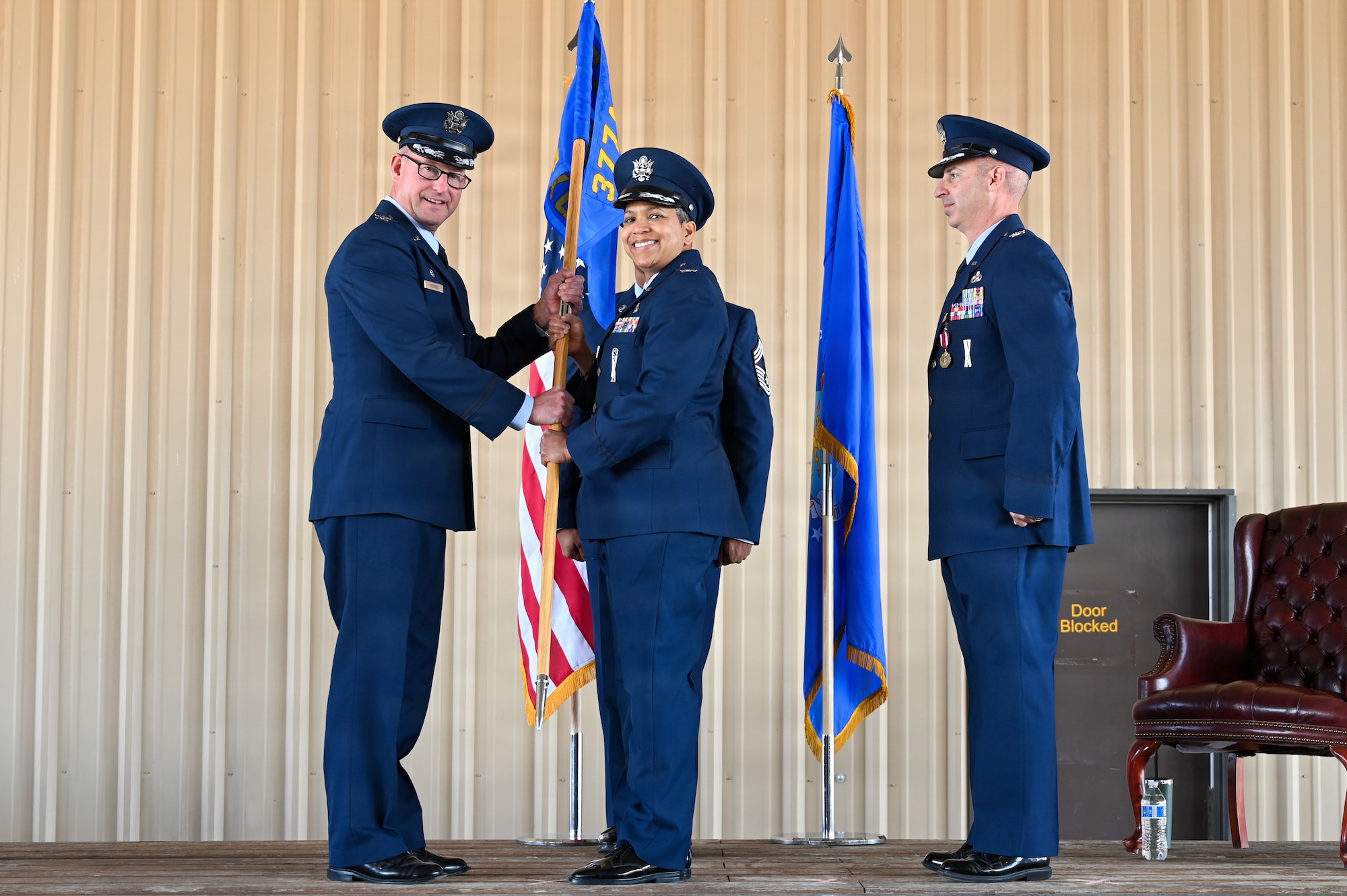 U.S. Air Force Col. presents the 377th Maintenance Group guidon to the incoming commander during a change of command ceremony.