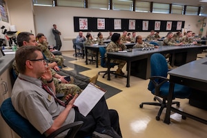 Military members talk during an air show meeting.