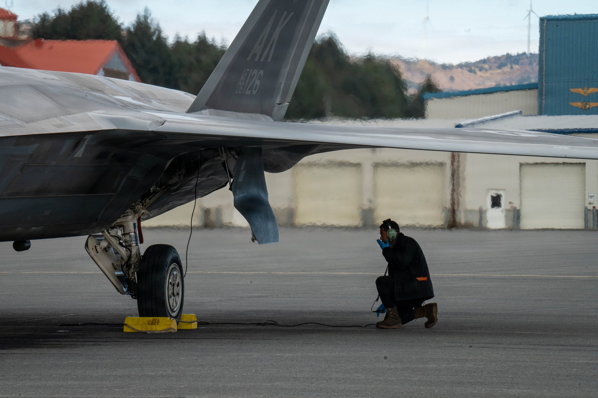 A U.S. Air Force Dedicated Crew Chief assigned to the 3rd Air Expeditionary Wing conducts a post-flight check on an F-22 Raptor aircraft assigned to the 3rd Wing during exercise Tropic Tundra 26 at U.S. Coast Guard Air Station Kodiak, Alaska, May 12, 2026.
