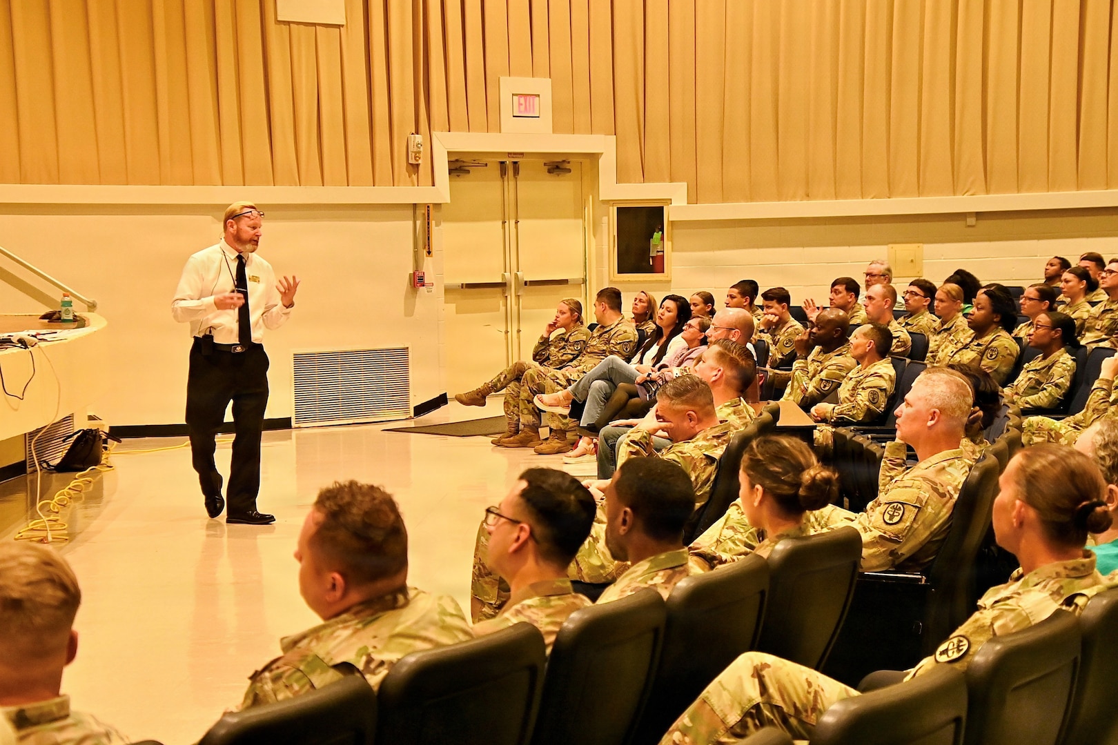 An instructor teaches about active shooters in front of a crowd of employees.