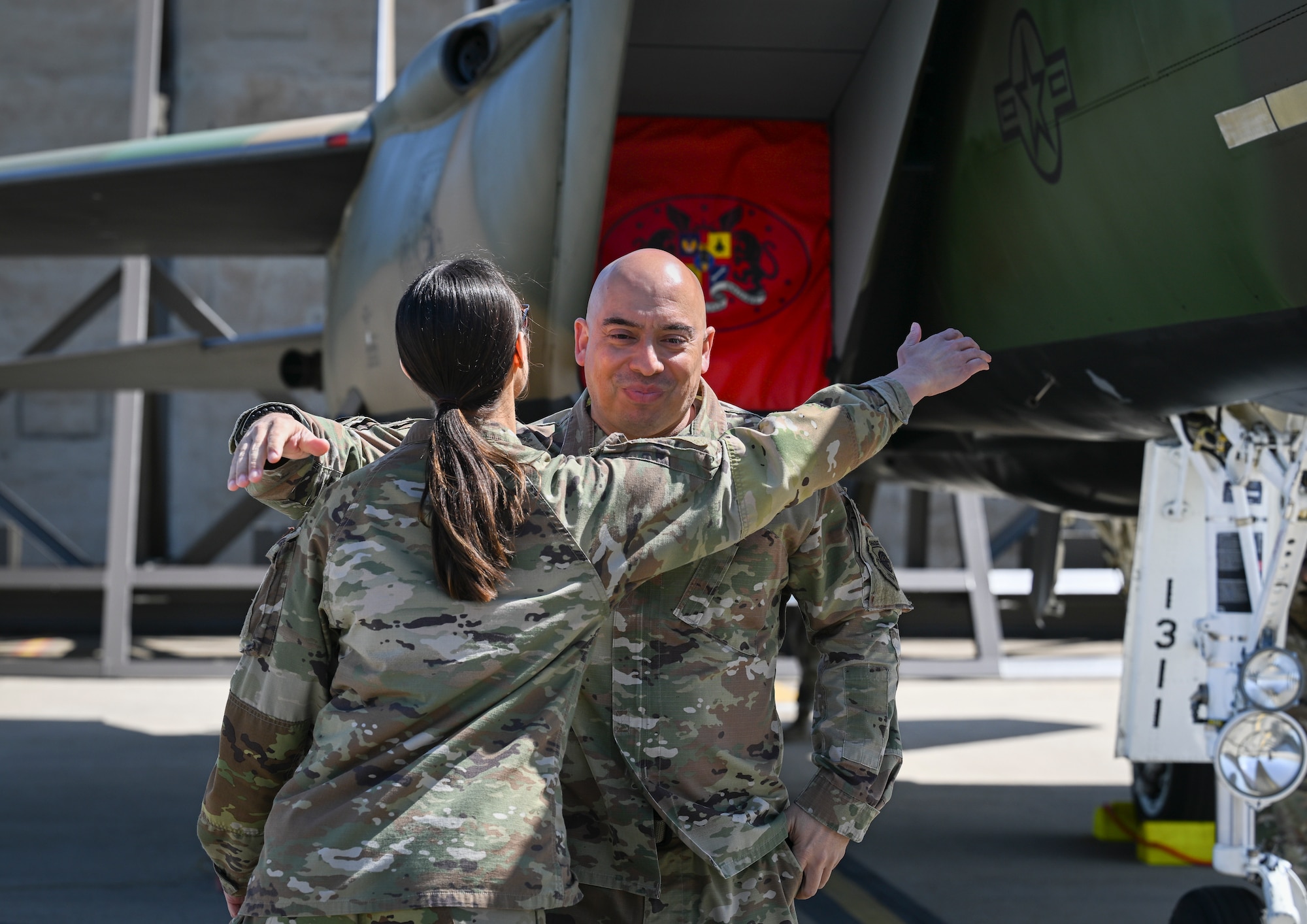 The command chief hugs the 48 EMS Squadron commander in front of the newly painted aircraft.