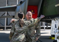 The command chief hugs the 48 EMS Squadron commander in front of the newly painted aircraft.