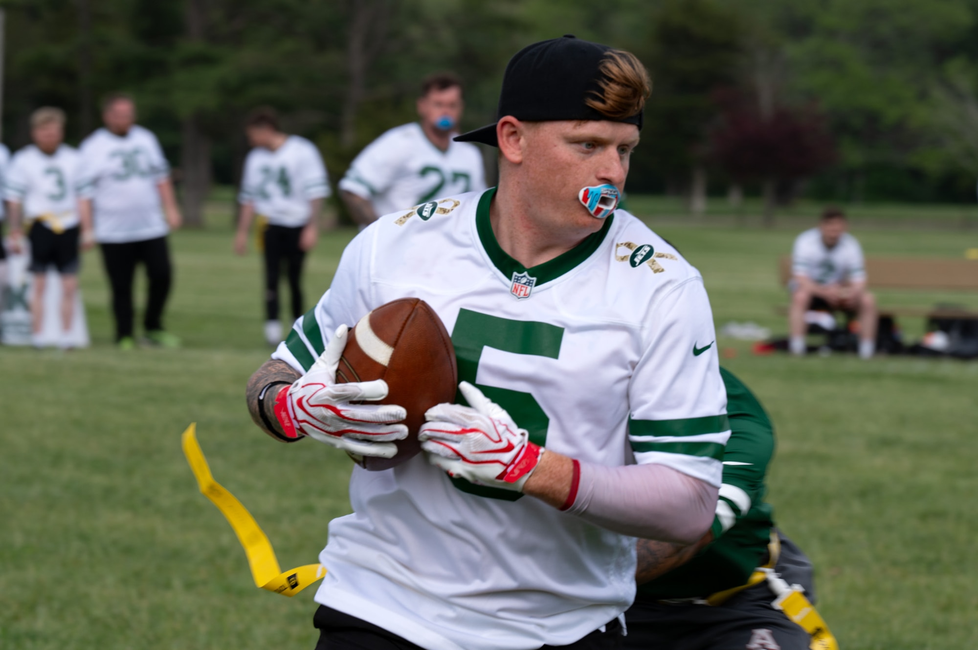 A British army soldier tries to avoid getting his flags pulled during the British army vs. Joint Base McGuire-Dix-Lakehurst flag football game at JB MDL, N.J., May 6, 2026. The New York Jets helped coordinate a flag football game during the Jets Fest for service members to attend and enjoy an afternoon of football. (U.S. Air Force photo by Airman 1st Class Haeleigh Bayle)
