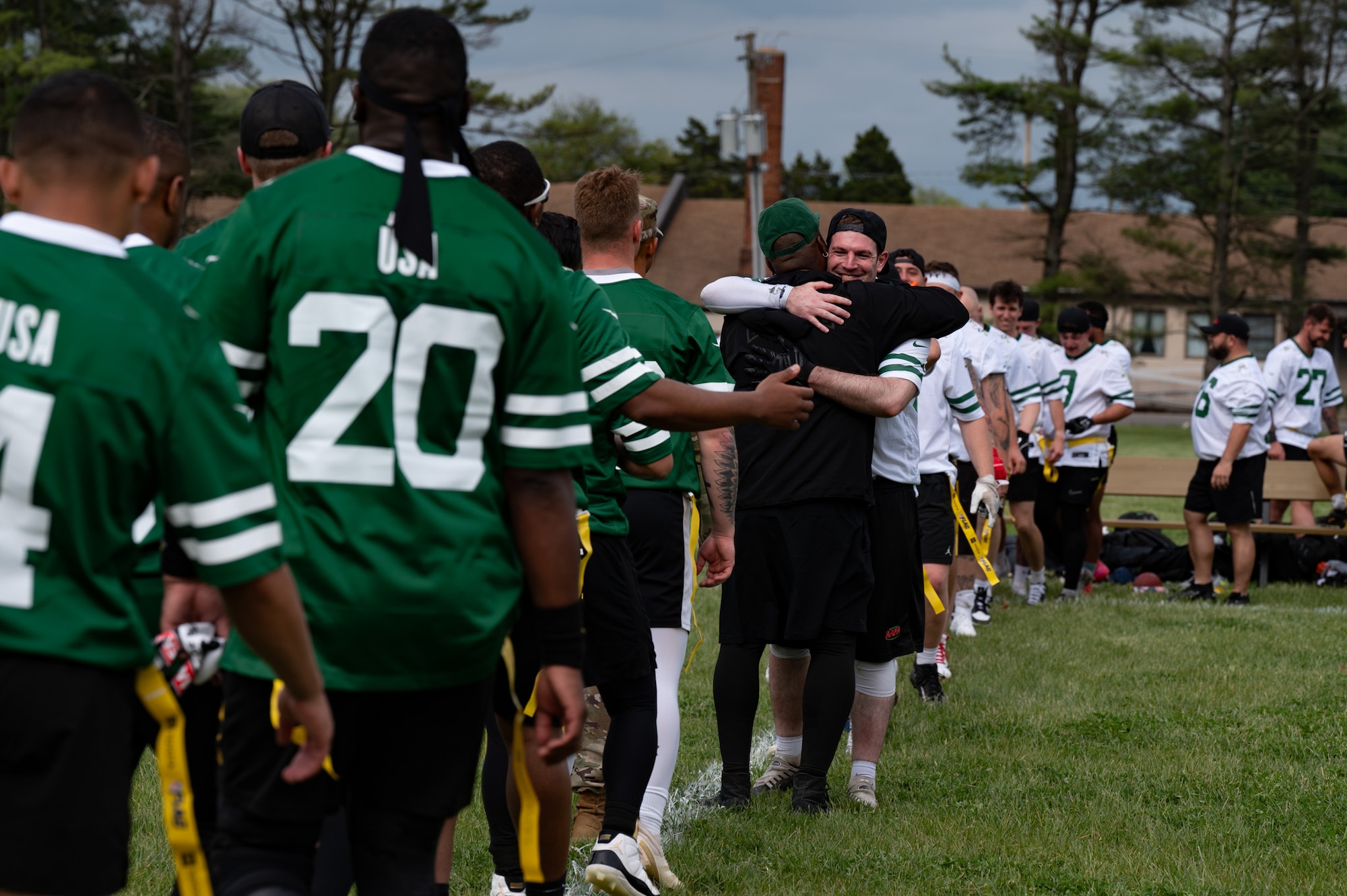 British army soldiers along with service members assigned to Joint Base McGuire-Dix-Lakehurst form lines to congratulate one another after a flag football game at JB MDL, N.J., May 6, 2026. The New York Jets helped coordinate the game so service members and families could enjoy an afternoon of football and interacting with allied forces. (U.S. Air Force photo by Airman 1st Class Haeleigh Bayle)