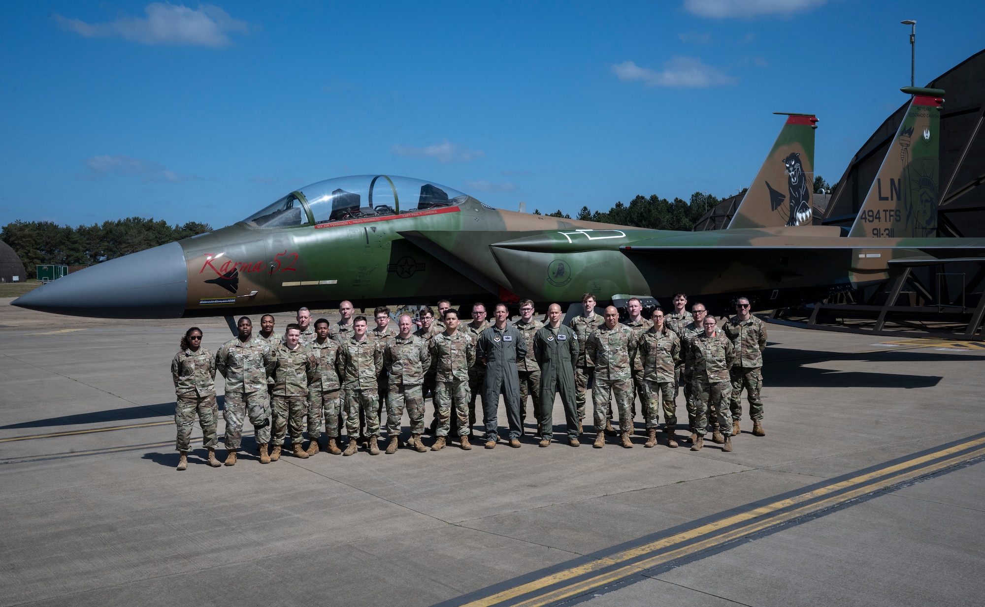 Airmen from the 48th Fighter Wing pose in front of the newly painted F15-E Strike eagle.