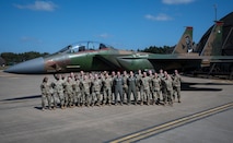 Airmen from the 48th Fighter Wing pose in front of the newly painted F15-E Strike eagle.