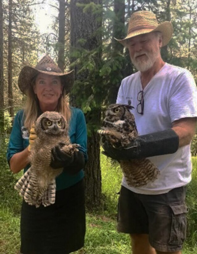 Photo of two people each holding an owl or "educational ambassador," that visitors will see during "Birds of Prey" event.