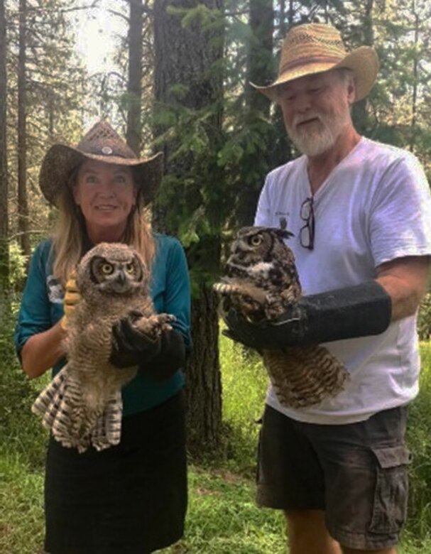 Photo of two people each holding an owl or "educational ambassador," that visitors will see during "Birds of Prey" event.
