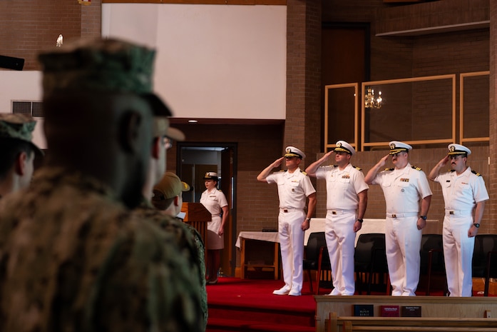 A photo of four men saluting during the National Anthem.