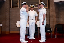 A photo of two men saluting each other.