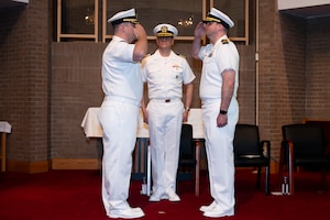 A photo of two men saluting each other.