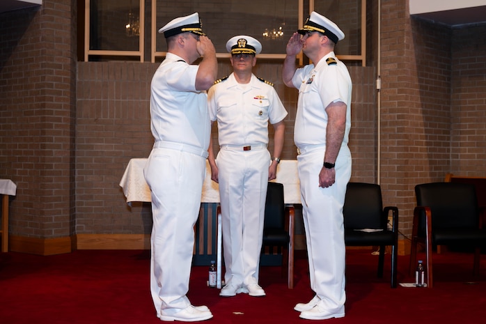 A photo of two men saluting each other.