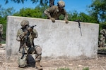 U.S. Air Force Airman Basic Vincent Sooamalelagi, 343rd Training Squadron Basic Defender Course student, posts security as U.S. Airman Basic Ricardo Espinal, 343rd TRS BDC student, clears a wall obstacle during an obstacle course portion of training on Joint Base San Antonio-Chapman Training Annex, Texas, May 11, 2026. Sooamalelagi and Espinal worked together as wingmen throughout the course clearing each obstacle working as a team. (U.S. Air Force photo by Joshua J. Garcia)