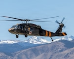 A Colorado Army National Guard UH-60 Black Hawk, specially marked with high-visibility orange paint for firefighting missions, departs for water bucket operations in Longmont, Colorado, April 24, 2026. The joint training with Colorado Division of Fire Prevention & Control enhanced coordination between military, civilian and interstate partners, ensuring air and ground crews are prepared to protect local communities from the threat of wildfires. Photo by Kaleb Gill.