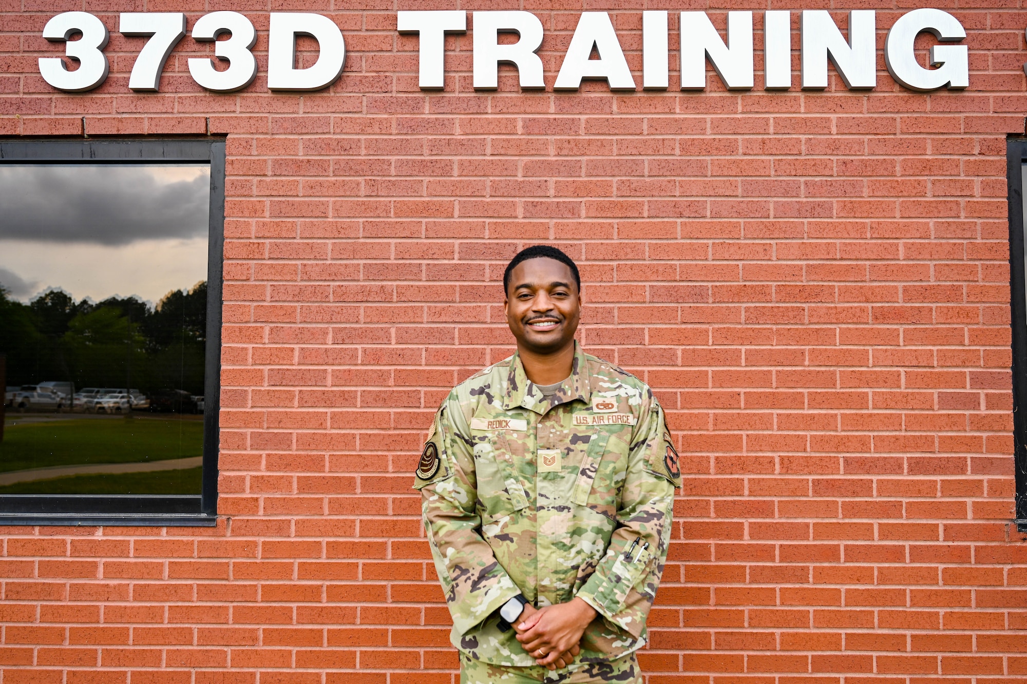 Man poses in front of wall.
