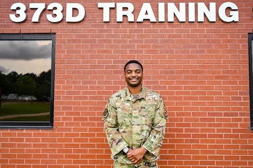 Man poses in front of wall.